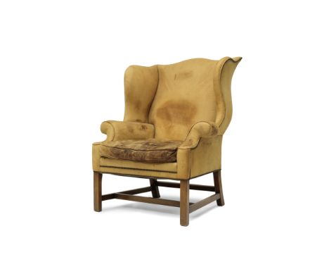 A George III style wingback armchairFirst half 20th centuryUpholstered in tan leather, on square section legs, 88cm wide x 86