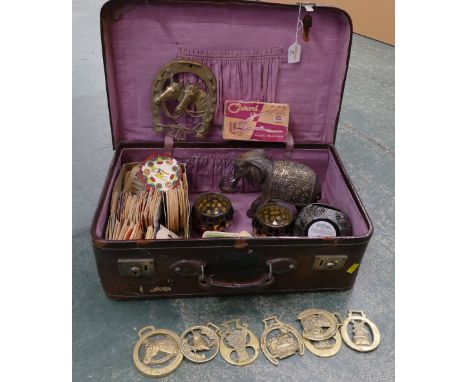 Vintage suitcase containing beer mats, horse brasses, candleholders etc