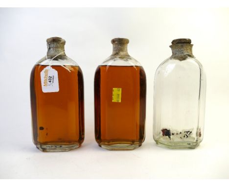 Two bottles of vintage alcohol in hexagonal bottles and empty bottle with partially perished label