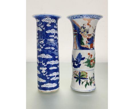 Two Chinese porcelain vases of cylindrical form: the first in blue and white, with flared rim, decorated with dragons amidst 