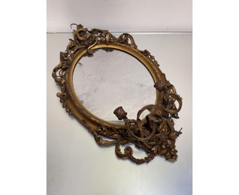 A 19th century giltwood and composition girandole mirror, the oval plate within a conforming frame modelled with scrolling fo
