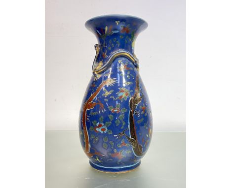 A large Chinese porcelain baluster vase, painted with opposing dragons and a flaming pearl against a blue ground, the shoulde