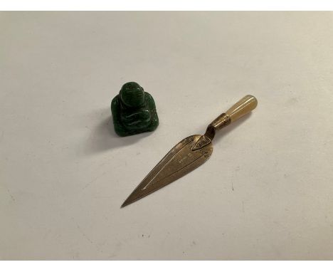 A silver page marker with mother of pearl handle in the form of a trowel and a jade miniature Buddha 