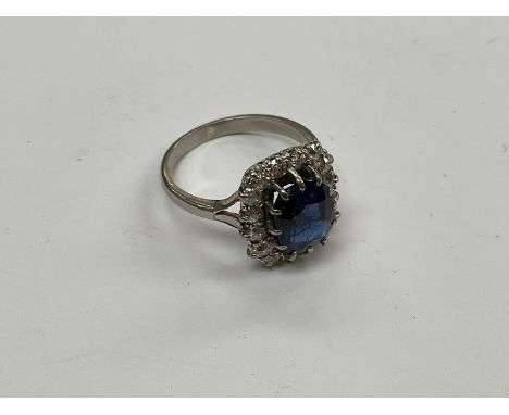 A sapphire and diamond ring, the central sapphire 9mm x 7mm, framed by 16 round cut diamonds, shank unmarked, size O, 5.9g 