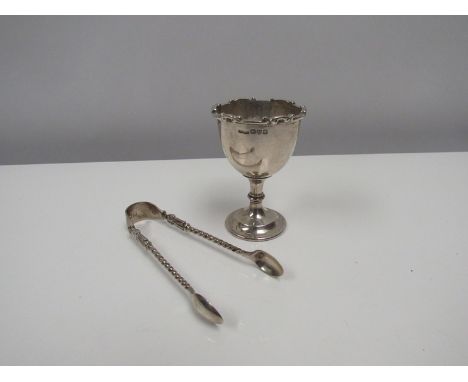 A Charles Perry &amp; Co. silver egg cup and pair of silver sugar tongs. 79g.  (2) 