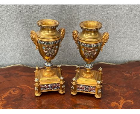 A pair of late 19th / early 20th Century gilt metal garnitures, scrolled enamelled detail, urn form, 26.5cm tall 