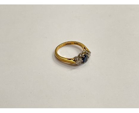 An 18ct gold sapphire and diamond ring, the central blue sapphire flanked by 0.20ct diamonds. Size K, 3.4g 