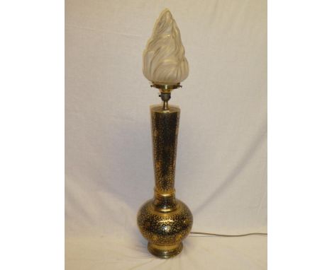 A 20th century middle Eastern brass table lamp with floral decoration and flaming torch glass shade 31½" high