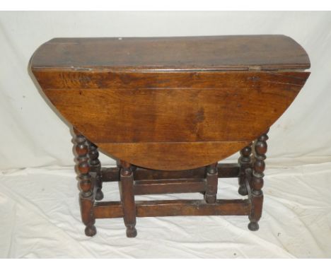 A Charles II oak oval gate-leg table on bobbin turned supports 43½" x 38"