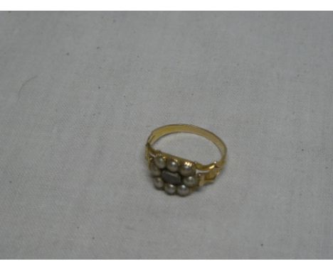 An early 19th century gold memoriam ring with scroll decoration and inset central hair panel surrounded by pearls