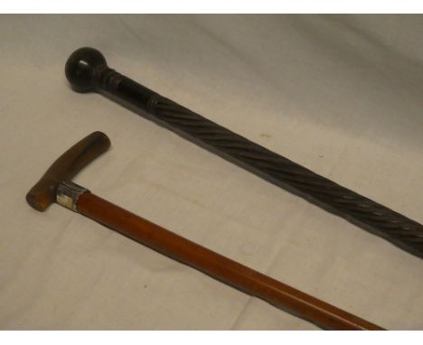 An African carved hardwood walking cane with spiral twist decoration and a gent's malucca and horn walking stick with silver 