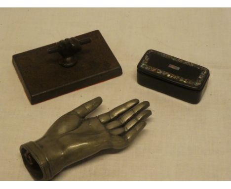 A 19th Century lacquered rectangular snuff box with mother of pearl inlaid lid, unusual pewter hand and a cast iron paperweig