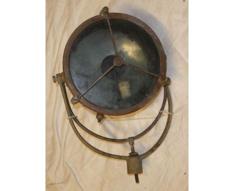 An old brass and copper nautical search light with circular lens and mounting bracket 18" high overall