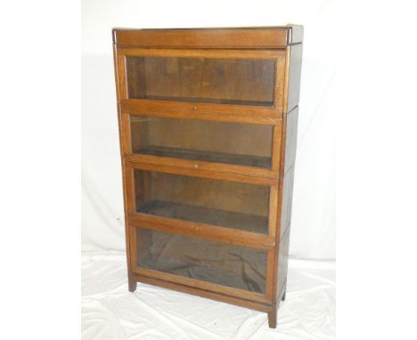 A Globe-Wernicke-style oak four tier stacking bookcase with folding glazed fronts