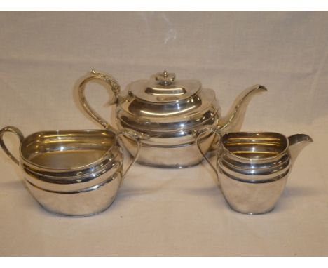 A good quality silver-plated three piece tea set comprising oval tea pot with scroll handle, matching sugar basin and milk ju