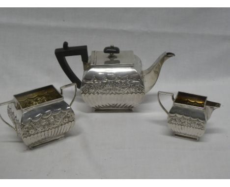 A George V silver rectangular tea-for-two set comprising rectangular teapot with raised floral decoration and ebonised handle