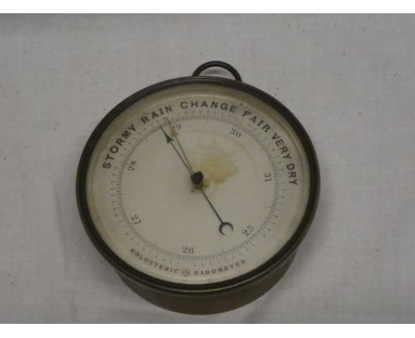 An old aneroid holosteric barometer with circular dial in brass circular case