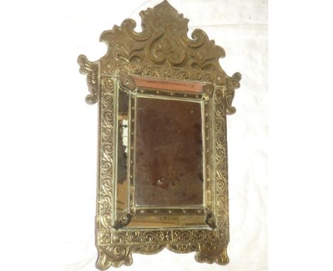 An unusual brass embossed rectangular cushion-framed mirror with raised scroll decoration 26" long (1 small panel missing)