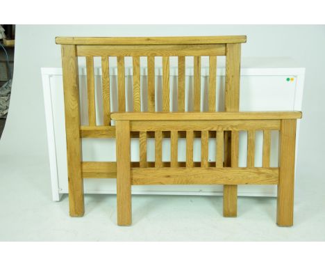 A modern light oak single bed
With slatted head and foot boards complete with side rails