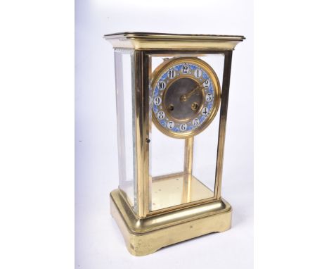 A brass and glazed eight day mantle clock early 20th CenturyThe gilt blue and white llcm dial with Arabic numerals, saucer be