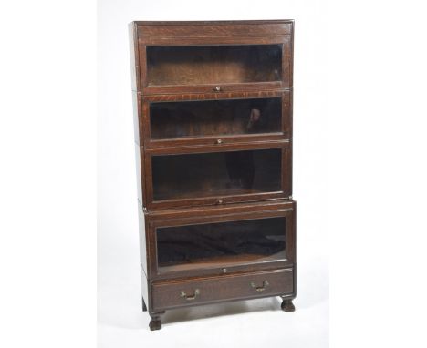 An oak early 20th Century Globe Werinick style stacking bookcaseWith four glazed tiers above a single frieze drawer, brass sw