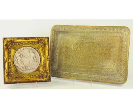 AN INDIAN BRASS REPOUSSÉ TRAY AND A DECORATIVE RESIN PLAQUE, GILT FRAME