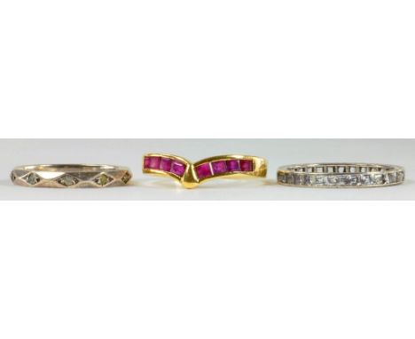 A RUBY DART RING WITH CALIBRE CUT RUBIES AND TWO DIAMOND ETERNITY RINGS, 6.4G