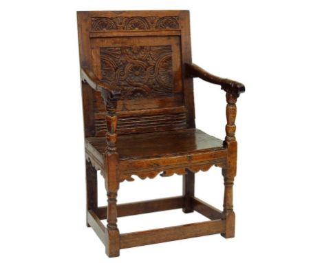A CHARLES II OAK PANEL BACK ARMCHAIR CARVED WITH LUNETTES AND GUILLOCHE 
