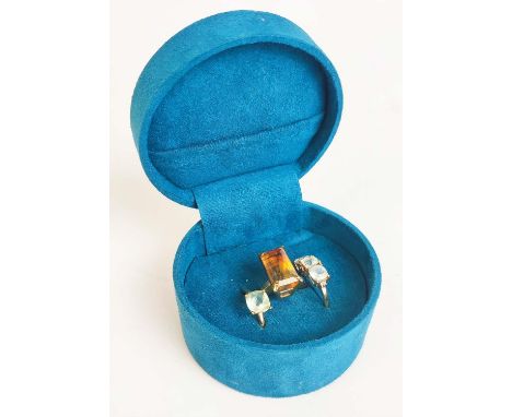 THREE 9CT GOLD DRESS RINGS, comprising a large single stone citrine set ring, size N½; a three stone topaz ring, size P; plus