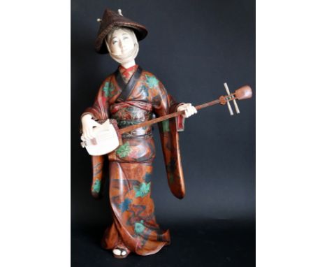 Japanese Ivory And Lacquered Wood Okimono, Depicting Geisha Girl Playing Shamisen (Three Stringed Musical Instrument)Wearing 