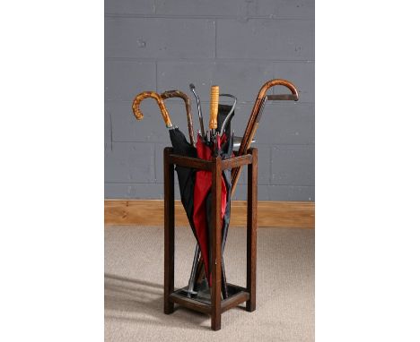 Oak stick stand containing a shooting stick, umbrellas and walking sticks