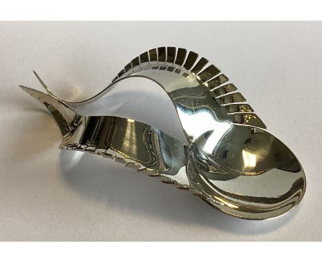 An unusual silver caddy spoon of stylised form to shaped body. Birmingham 2018. By Karina Gill. Approx. 27 grams.