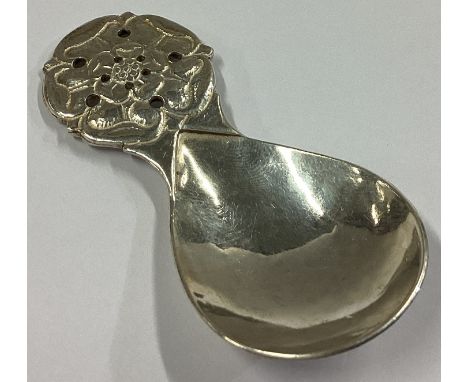 GUILD OF HANDICRAFTS: A heavy cast silver caddy spoon with rose finial. Approx. 27 grams.