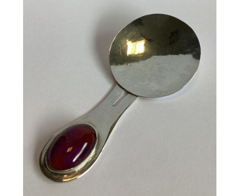 A large silver stone-set caddy spoon of circular form. London 1979. By EP. Approx. 32 grams.