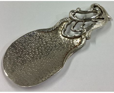 A good chased Continental silver caddy spoon with scroll decoration. Approx. 28 grams. 