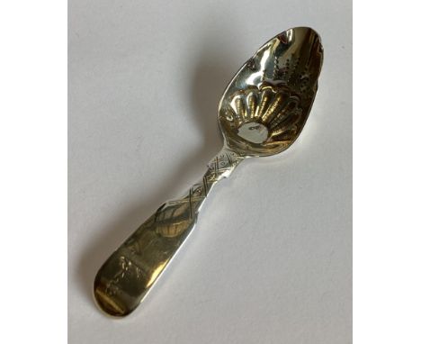 A silver and silver gilt caddy spoon with chased decoration. London. By DP. Approx. 16 grams.