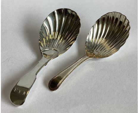 A Georgian silver caddy spoon with fluted bowl together with a Victorian example. Approx. 28 grams.