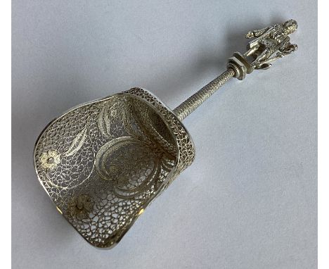 An Antique silver filigree caddy scoop with figural finial. Approx. 18 grams.