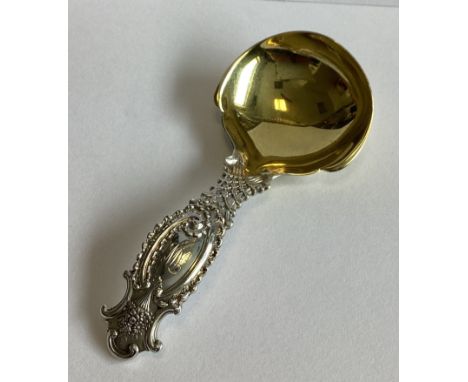 TIFFANY & CO: A good quality cast silver and silver gilt caddy spoon decorated with flowers. Approx. 29 grams.
