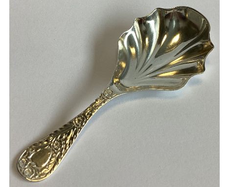 CHESTER: A chased silver caddy spoon with fluted bowl. By MF. Approx. 17 grams.