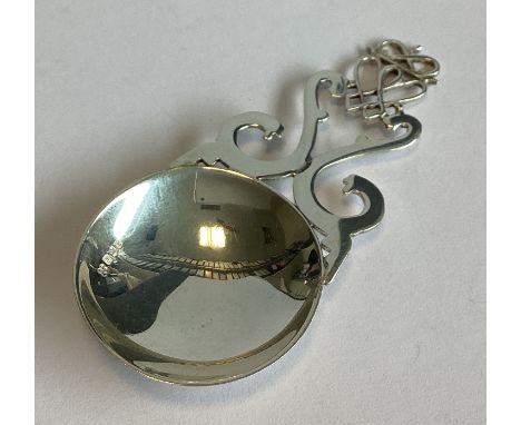 EDINBURGH: A small pierced Scottish silver caddy spoon with scroll decoration. 1985. By PD&Co. Approx. 10 grams.