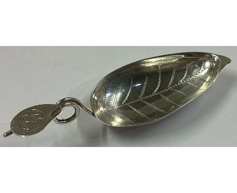 A Georgian silver leaf-shaped caddy spoon with scroll thumbpiece. Birmingham 1823. Approx. 5 grams.