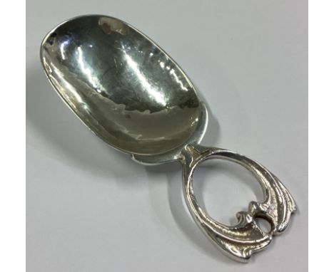 A E JONES: A heavy silver caddy spoon of stylised form to textured bowl. Birmingham 1945. Approx. 20 grams.