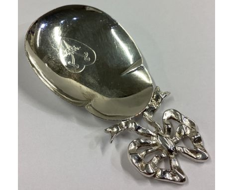 A large Continental silver caddy spoon with ribbon decoration. Approx. 24 grams.