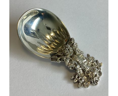 TIFFANY & CO: A small cast silver caddy spoon with floral decoration. Approx. 17 grams.