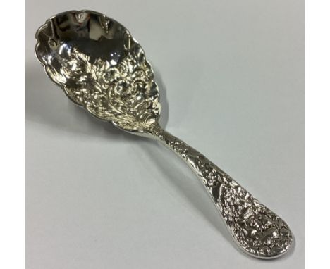 CHESTER: A chased silver caddy spoon with floral decoration. By MP. Approx. 18 grams.