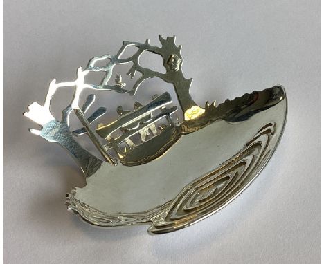 An unusual pierced silver caddy spoon decorated with a couple sat beneath trees. London 2017. By Jen Ricketts. Approx. 29 gra
