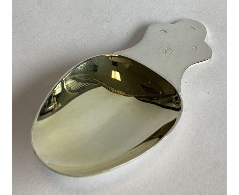 A large heavy silver and silver gilt caddy spoon of stylised form. Birmingham. By R&R. Approx. 33 grams.