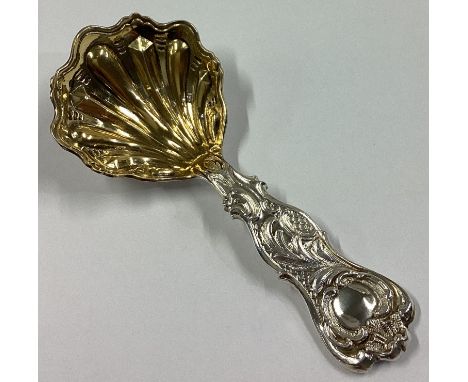 A heavy Victorian silver and silver gilt caddy spoon chased with scrolls and flowers. London 1862. By EH. Approx. 25 grams.