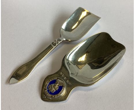 A commemorative silver and enamelled caddy scoop. Birmingham. By WHH. Together with another similar example. Approx. 29 grams